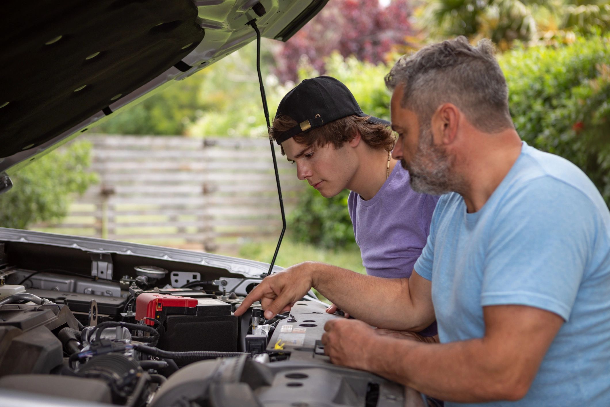 Youth learning auto repair skills at the shop